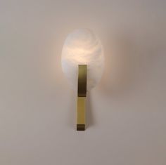 a light that is on the side of a wall with a ball attached to it