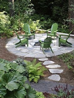 a fire pit surrounded by green chairs and plants in the middle of a garden area