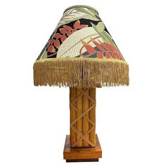 a lamp that is sitting on top of a wooden base and has a colorful shade