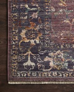 an area rug with various colors and patterns on it, sitting on a wooden floor