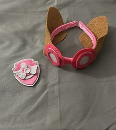 a pair of pink goggles sitting on top of a bed next to a patch