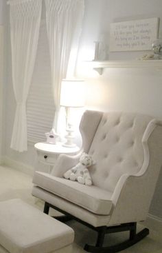 a baby's room with a rocking chair and foot stool