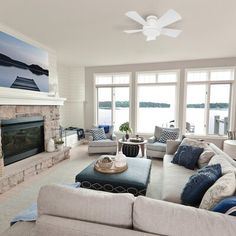 a living room filled with furniture and a fire place in front of a large window