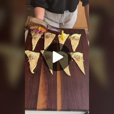 a person cutting up food on top of a wooden table