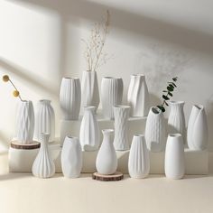 a group of white vases sitting next to each other