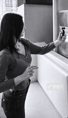 a woman is standing in front of a sink and looking at the faucet