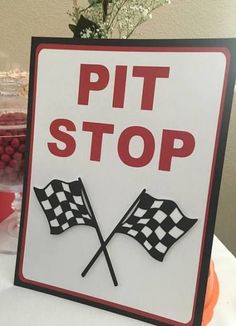 a sign that says, pitt stop with two crossed checkered flags in front of it