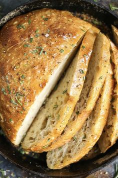 sliced bread in a cast iron skillet with herbs on top