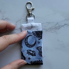 a person is holding onto a keychain that has a small pouch on it