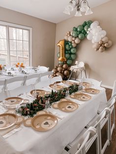 a table set up for a party with plates and balloons in the shape of numbers