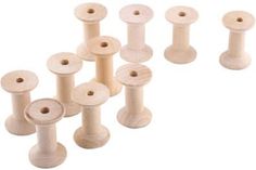 several wooden spools are lined up on a white surface