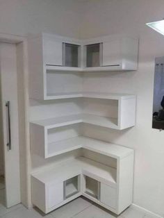 an empty room with white shelves and cupboards