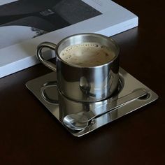 a cup of coffee sitting on top of a saucer next to a cookbook