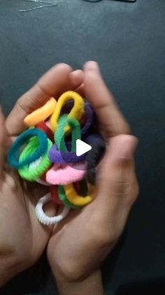 a person is holding some colorful hair clips in their hands and they are showing the video