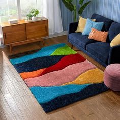 a living room with a blue couch and colorful rug