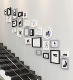 there are many pictures on the wall next to the stair case in this room with black and white stairs