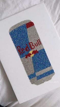 a red bull beer bottle beaded onto a white canvas