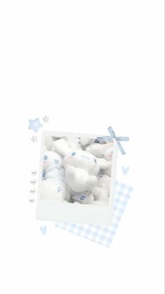 a box filled with white teddy bears on top of a checkered table cloth