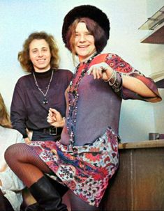 two women sitting next to each other in front of a wall