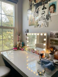 a vanity with lights on it in front of a window and a chair next to it