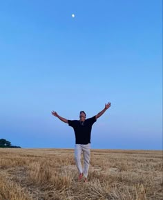 a man standing in a field with his arms outstretched