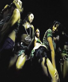 a group of young women sitting next to each other in front of a black background