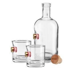 an empty glass bottle and two shot glasses with a wooden stopper on the bottom