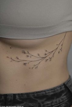 a woman's stomach with small flowers on the side, showing her lower back