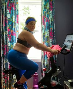 a woman on a stationary bike in front of a window