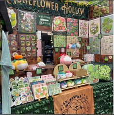 an outdoor flower shop with lots of flowers and cards for sale on the outside wall