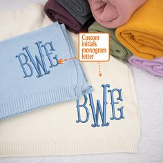 a blanket with the words bwf on it next to folded blankets and pillows