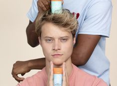 a man getting his hair brushed by another person