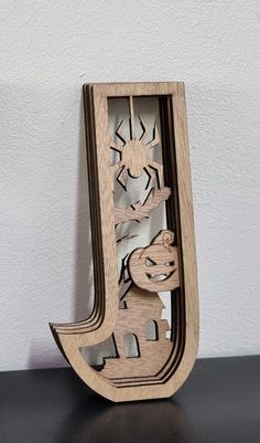 the letter j is made out of wood and has an image of animals on it