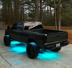 a black truck with blue lights in the bed