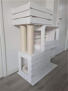 a cat house made out of pallets and wooden boards with a scratching post attached to the top