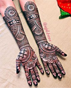 two hands with henna designs on them