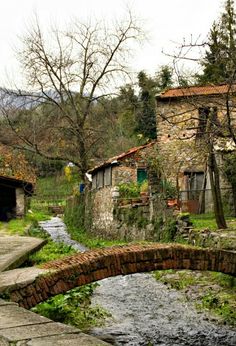 an old stone building with a small bridge over it