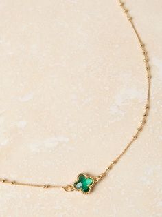 This dainty necklace features a vibrant emerald crystal charm, its rich green hue catching the light with every movement. The delicate gold ball chain adds a touch of understated elegance, making it perfect for everyday wear or special occasions. Dainty Green Jewelry With Delicate Chain, Elegant Green Charm Necklace With Delicate Chain, Green Pendant Necklace With Delicate Chain, Dainty Green Emerald Necklace With Delicate Chain, Delicate Green Necklace With May Birthstone, Delicate Green May Birthstone Necklace, Emerald Necklaces With Delicate Green Chain, Delicate Green Charm Necklaces With Delicate Chain, Green Charm Necklace With Adjustable Chain For May Birthstone