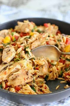 a skillet filled with chicken and rice on top of a checkered table cloth