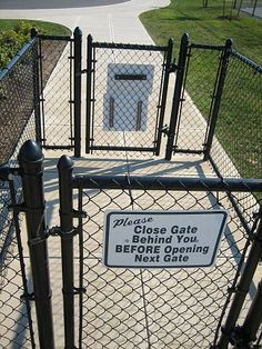 a gate with a sign on it that says, the close gate behind you before opening