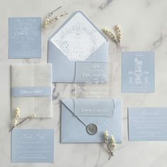 the wedding stationery is laid out on a marble table