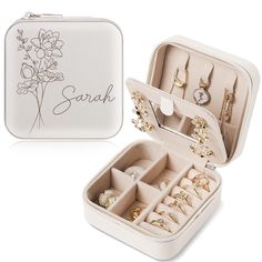 an open jewelry box with rings and bracelets in it on a white surface next to the opened case