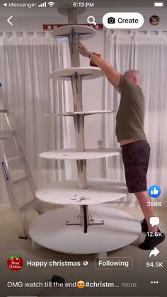 a man standing on top of a white shelf next to a ladder