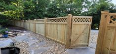 a large wooden fence next to a stone walkway