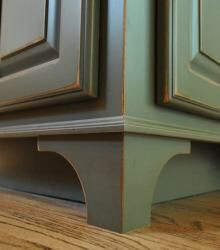 the corner of a kitchen cabinet with wood flooring and green painted paint on it