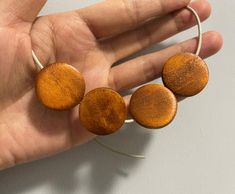 three wooden discs are being held in the palm of a person's hand,