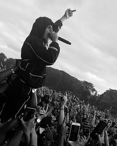 a man in a hoodie holding a microphone up to the crowd