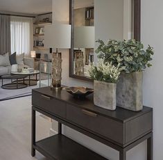 a living room filled with furniture and a large mirror on top of a wooden table