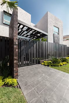 the entrance to a modern house with an iron gate