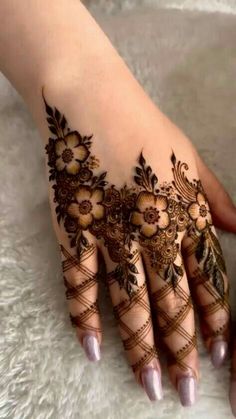 a woman's hand with henna tattoos on it